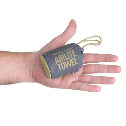 Sea To Summit Airlite Travel Towel Large packed in its carry case shown in someones hand