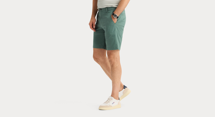 Side view of model wearing Duck Green Ultimate 9.5" Shorts, Straight Fit.